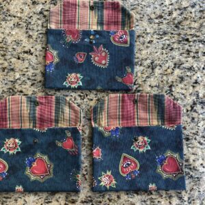 Pochette en coton enduit motif cœurs, roses, papillons, ailes, crânes et œils Multicolore sur fond vert. Tissu Intérieur bandes multicolores